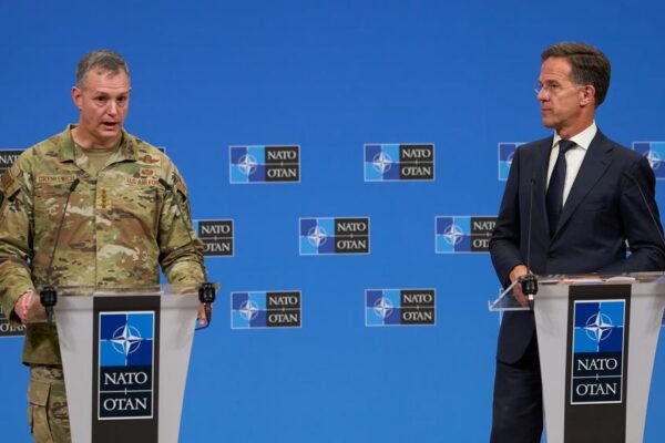 A U.S. general and NATO’s secretary general speak at podiums during a
press conference.