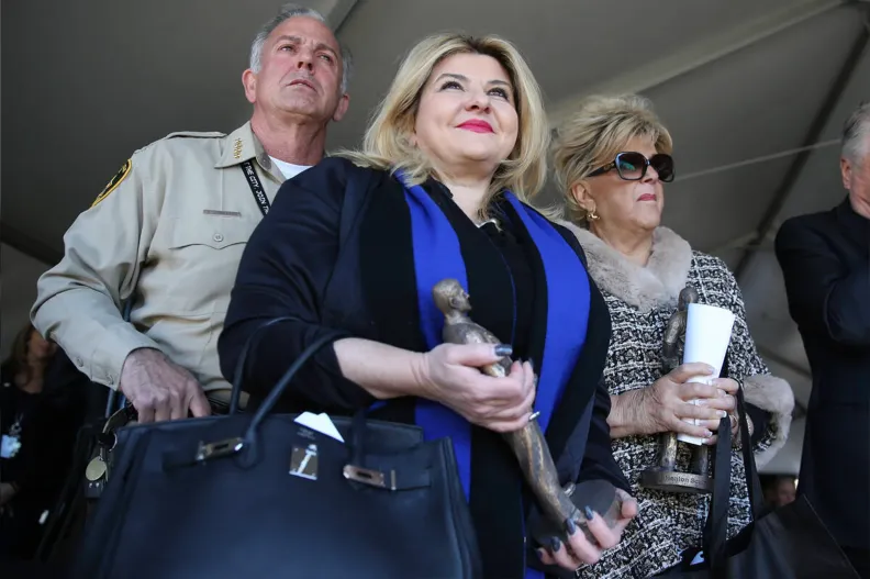 Joe Lombardo, Michele Fiore, and Carolyn Goodman in a row. Michele holds a statue of Alyn Beck.