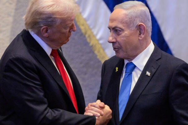 US President Donald Trump (L) holds hands and speaks with Israeli Prime Minister Benjamin Netanyahu at the Israeli parliament, the Knesset, in Jerusalem on October 13, 2025.