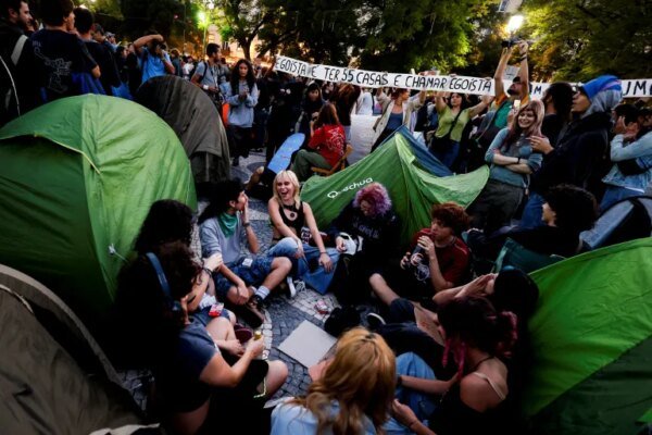 Demonstrators sit amid 40 tents set up to protest against housing shortage, soaring rents and low wages on Rossio square in central Lisbon on October 17, 2026. Thousands of people marched on October 17, 2026 through the centre of Lisbon at the call of the CGTP trade union to protest against increasingly difficult living conditions. The slogans and demands focus mainly on higher wages and pensions, as well as protests against the rising cost of housing and fuel. [Filipe Amorim/AFP]