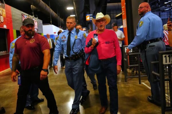 Police remove a protester as President Donald Trump speaks at a campaign rally at Heartland...