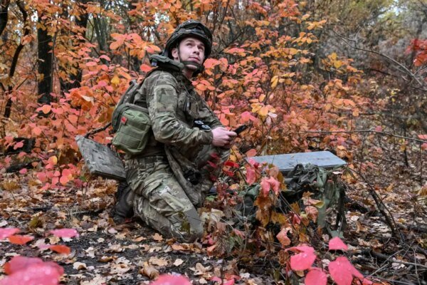 An artilleryman of the Special Rifle Police Battalion sets up a Starlink satellite internet system near the frontline in Donetsk region.