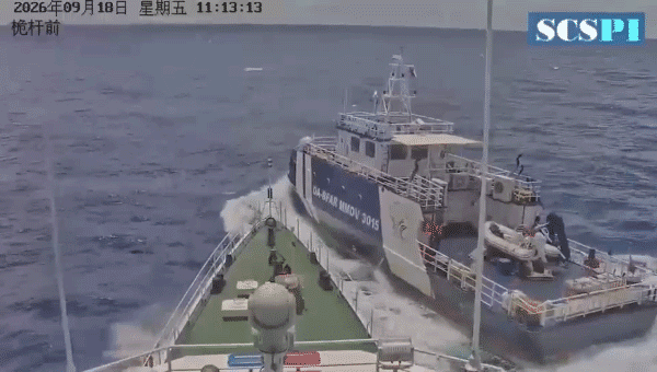 View from the bow of a ship directly approaching a Philippine Bureau of Fisheries and Aquatic Resources vessel, marked DA-BFAR MMOV 3015, as it crosses close by in open water