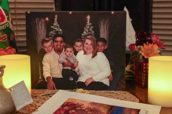 A photo of Jose and Courtney Fiscal Belli with their children Silas Dick, left, Legend Fiscal Belli, seated, Tennessee Dick and Rafael Fiscal Belli, right, sits on a table surrounded by candles at the family's home on Oct. 9, 2026, in Paris, Illinois. (Stacey Wescott/Chicago Tribune)