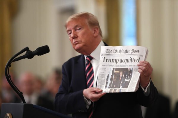 In February 2020, U.S. President Donald Trump holds up the front page of The Washington Post (WP), which carried a story on his acquittal in the impeachment trial. He later sharply pressured the press by filing a defamation lawsuit over an opinion column in the WP. [Bloomberg]