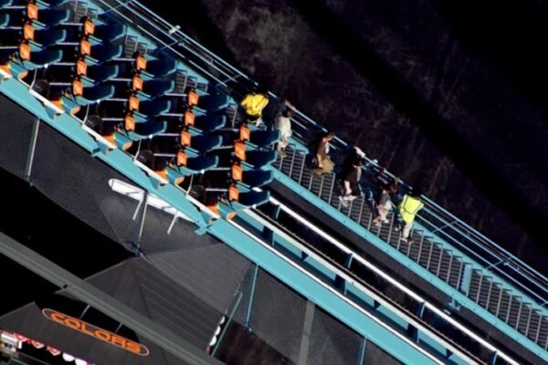 Riders are escorted off the Goliath roller coaster at Six Flags Over Georgia on Monday.