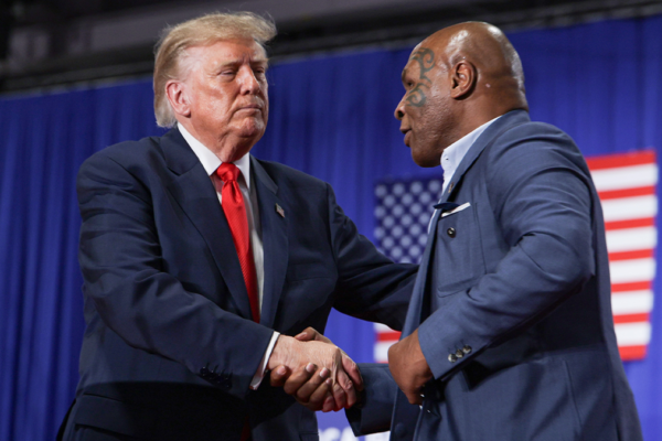U.S. President Donald Trump (L) shakes hands with Former professional boxer Mike Tyson after he was introduced during an election rally at the Oncenter on October 09, 2026 in Syracuse, New York. Trump is in New York campaigning for local Republican candidates ahead of the midterm elections.